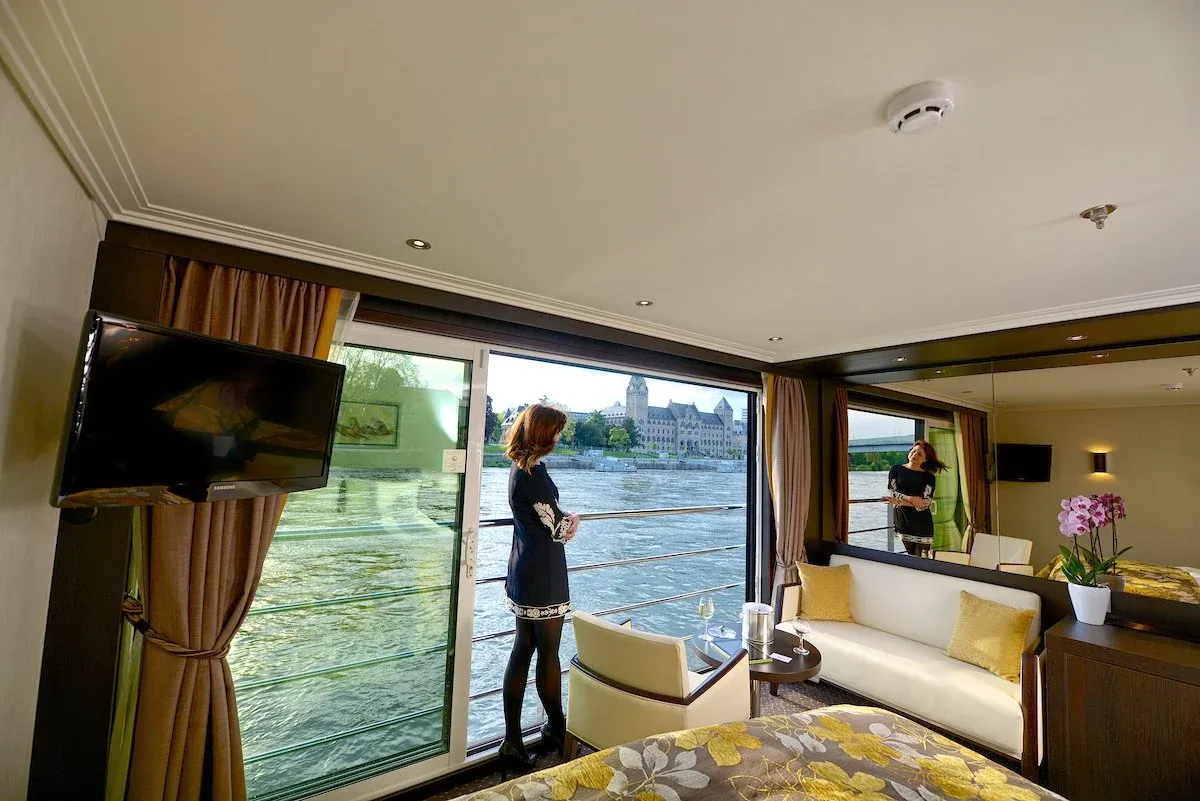 Woman standing on the balcony of her cruise ship suite