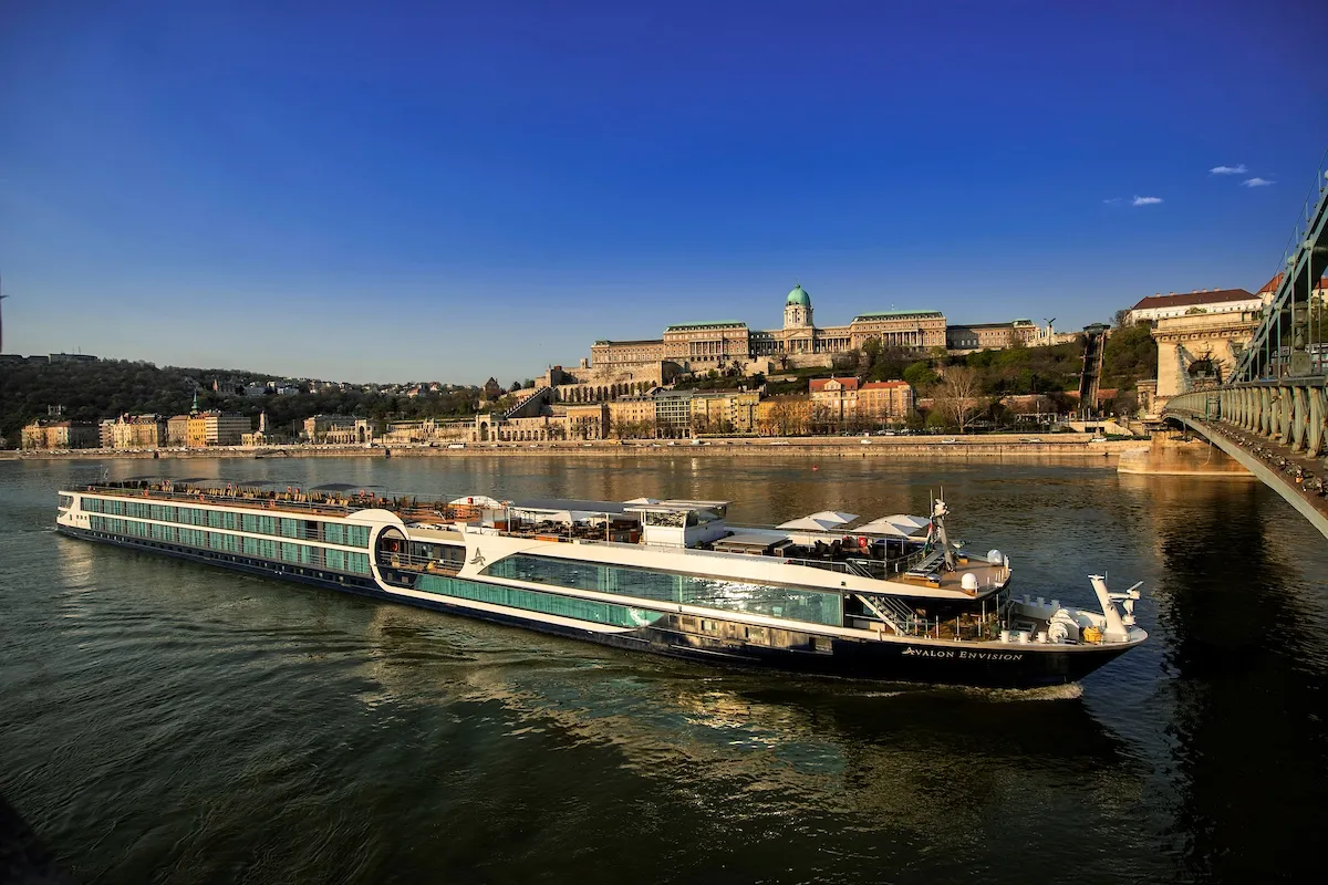 Avalon Waterways cruise ship sailing on a river next to a city in Europe