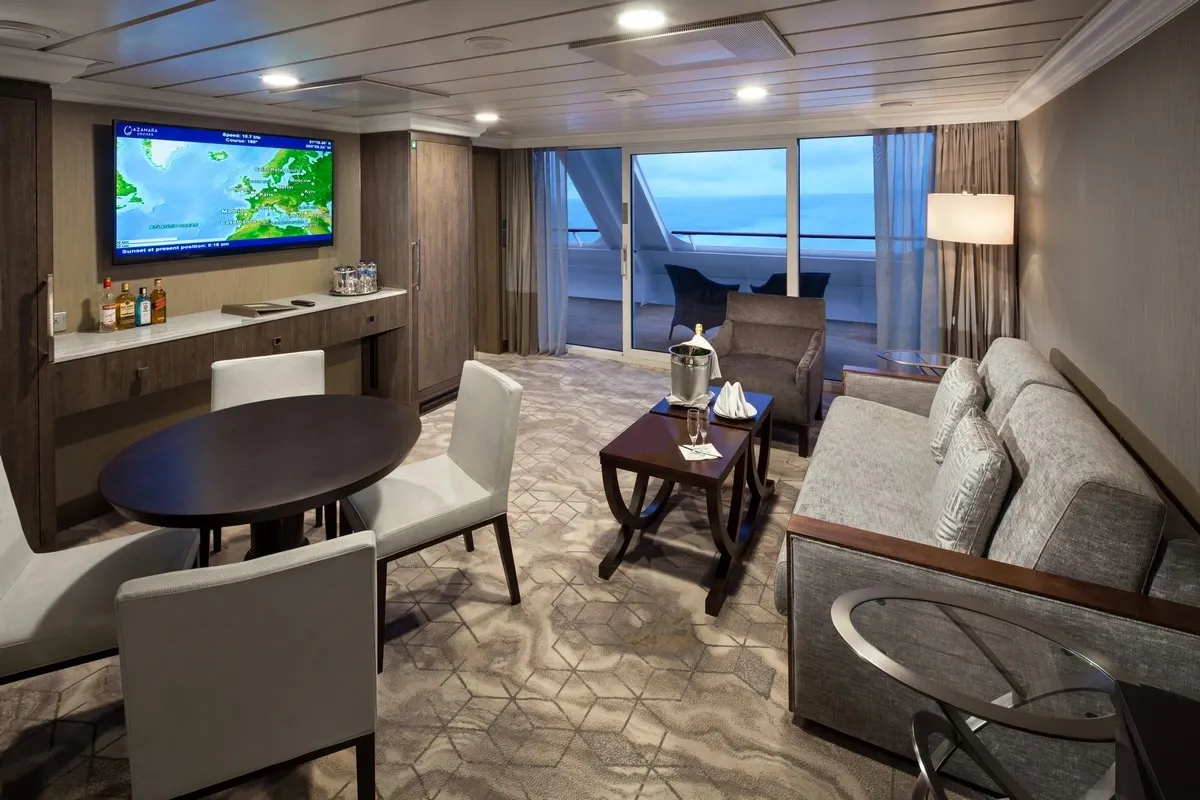 Living space inside of a suite with sofa, table and tv