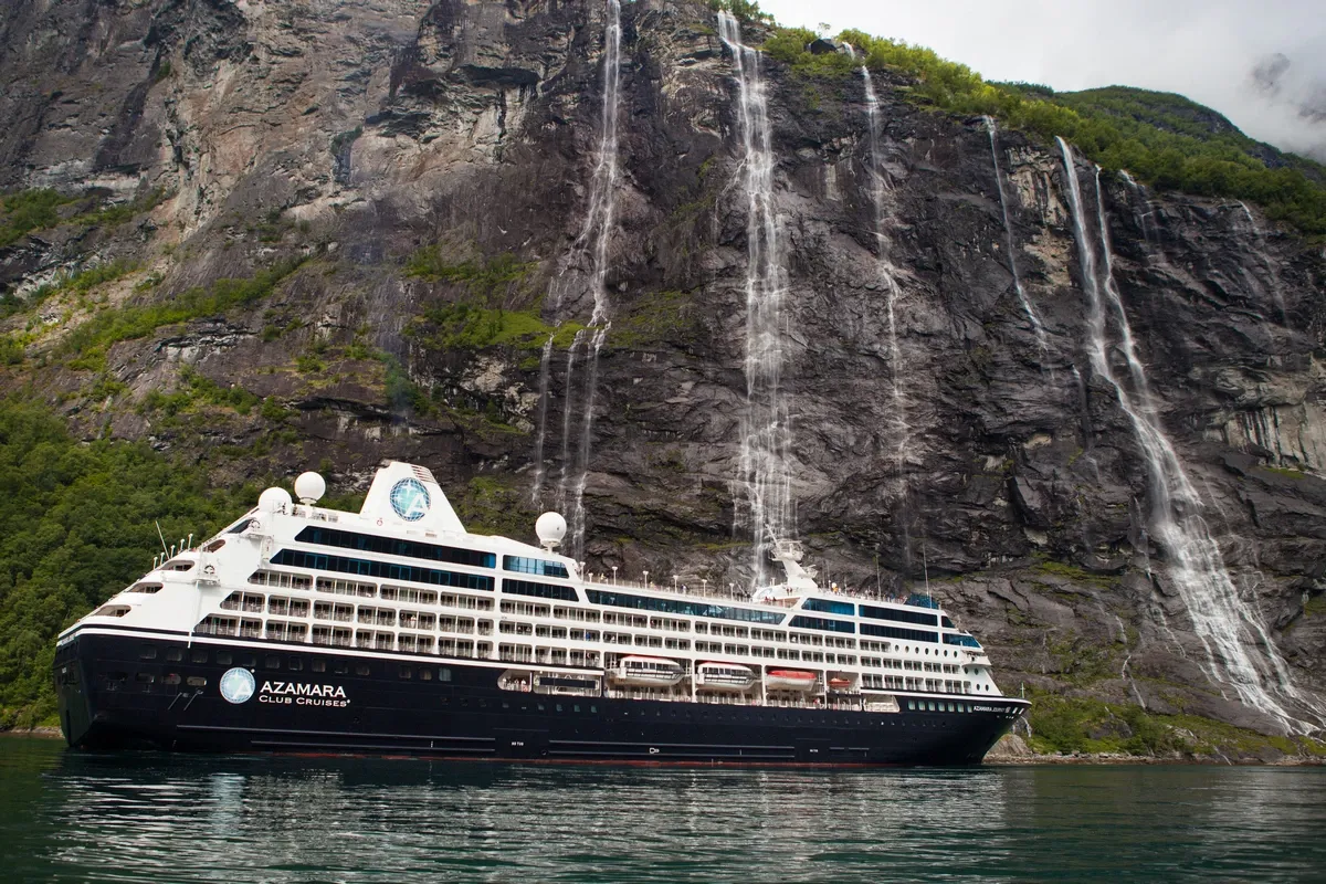Cruise ship sailing next to a mountain