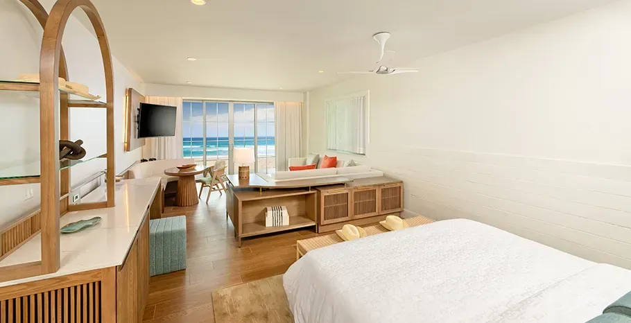 Spacious room with a queen bed and a view to the beach