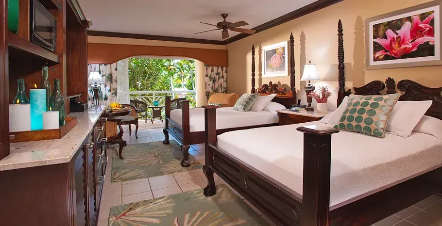 Room with two queen beds, living space and garden views