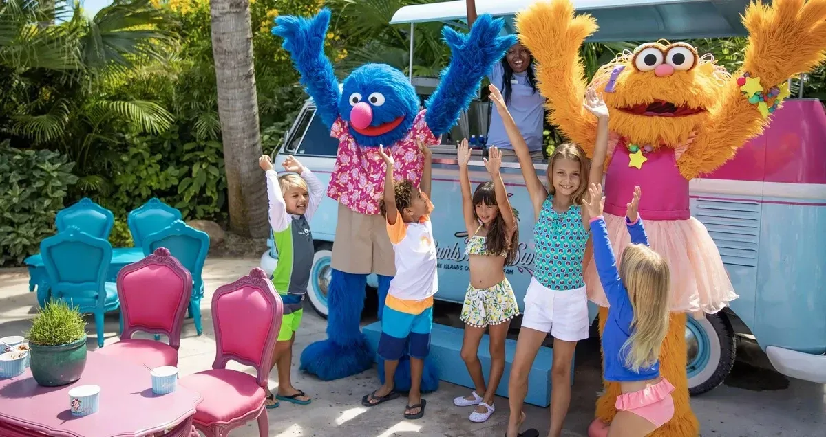 Sesame Street characters taking a picture with a group of kids