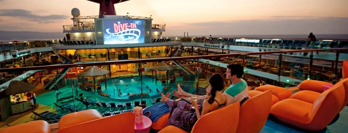 People hanging out at the top deck of a cruise ship watching a movie