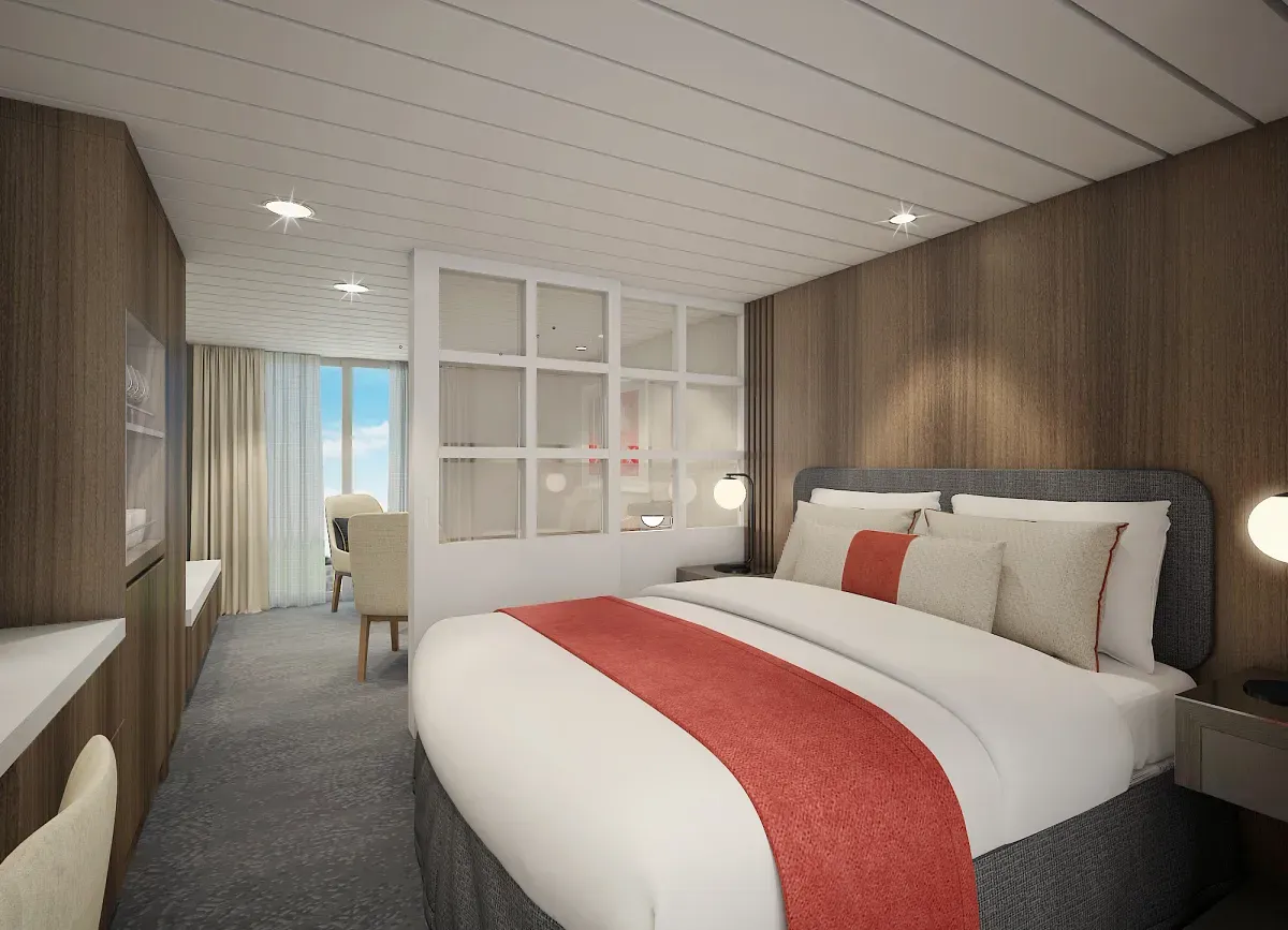 Cruise ship suite with a king bed and living space