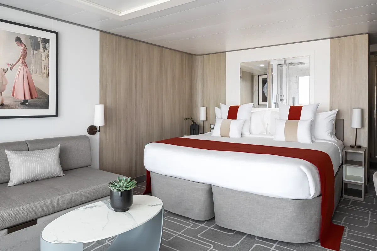 Cruise ship suite with a king bed and living space