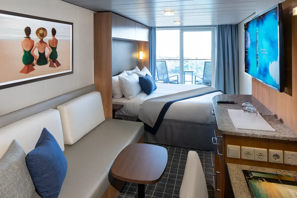 Cruise ship suite with a king bed and living space
