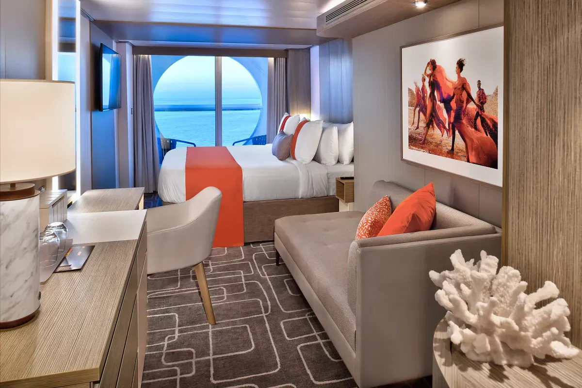 Cruise ship suite with a king bed and living space