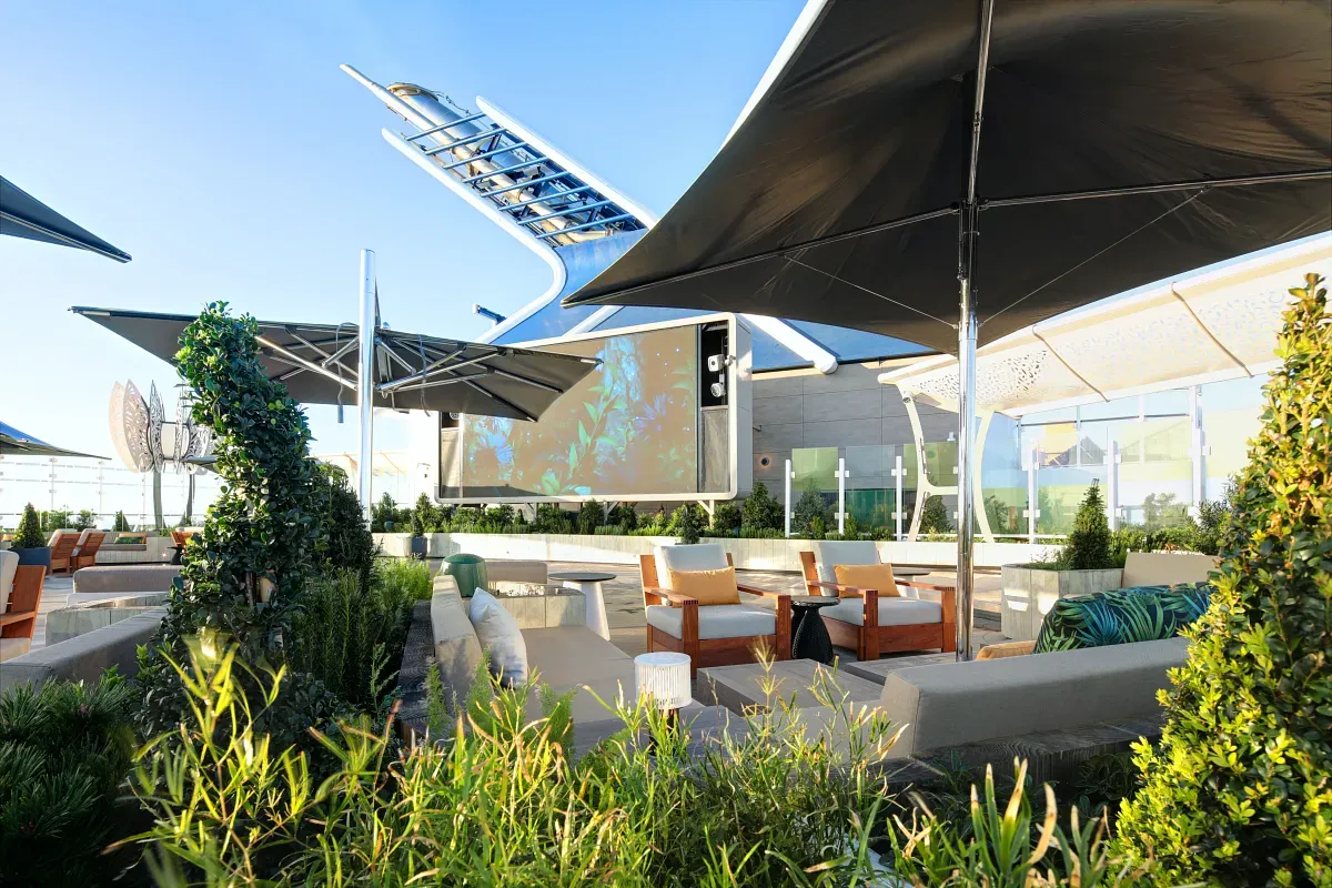 Top deck of the cruise ship with living space, plants and a big screen on the background