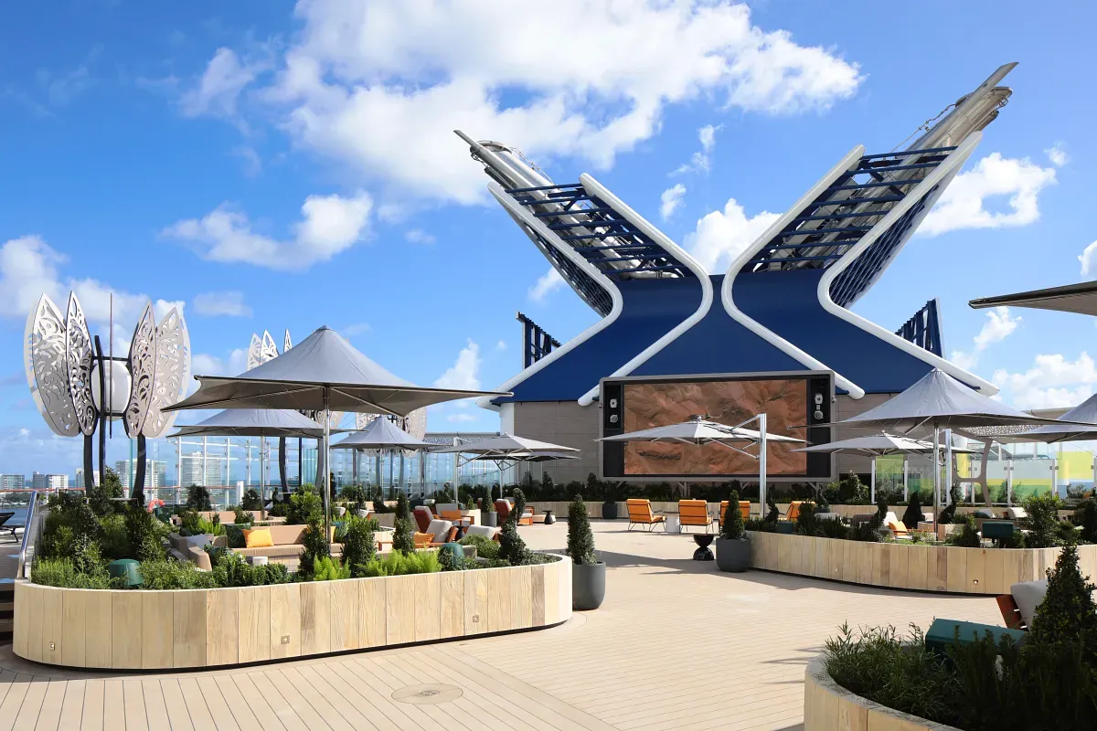 Top deck of the cruise ship with living space, plants and a big screen on the background