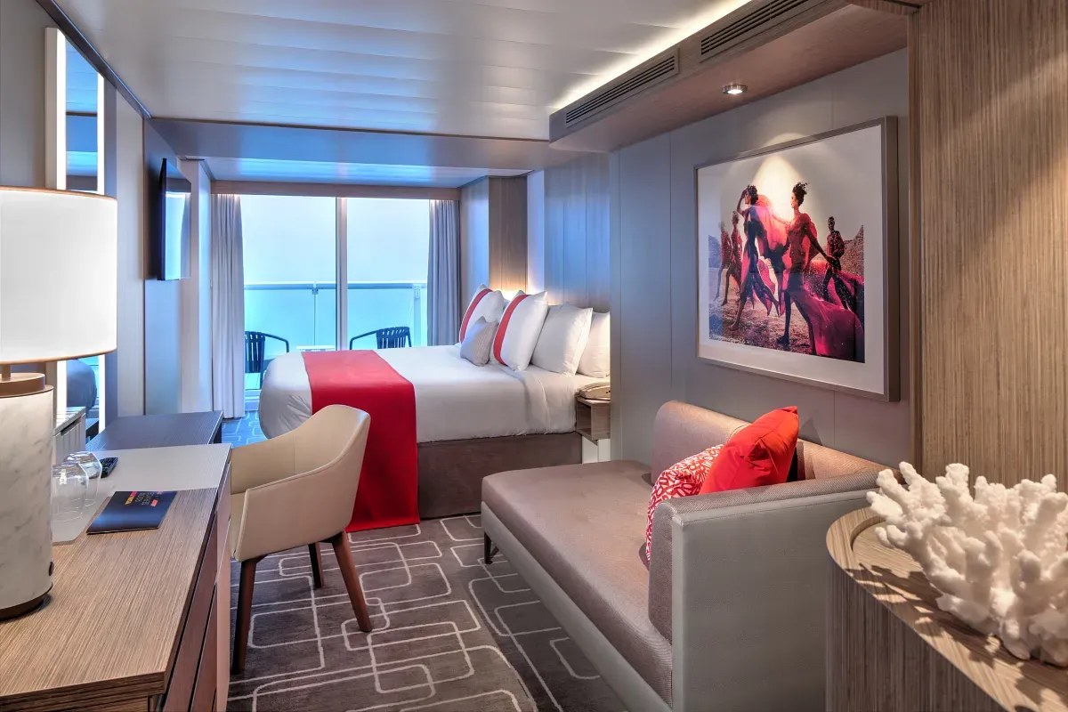 Cruise ship suite with a queen bed and living space