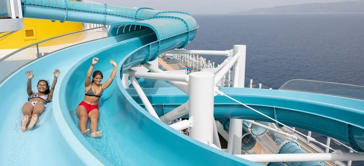 Two women going down a waterslide on a cruise ship