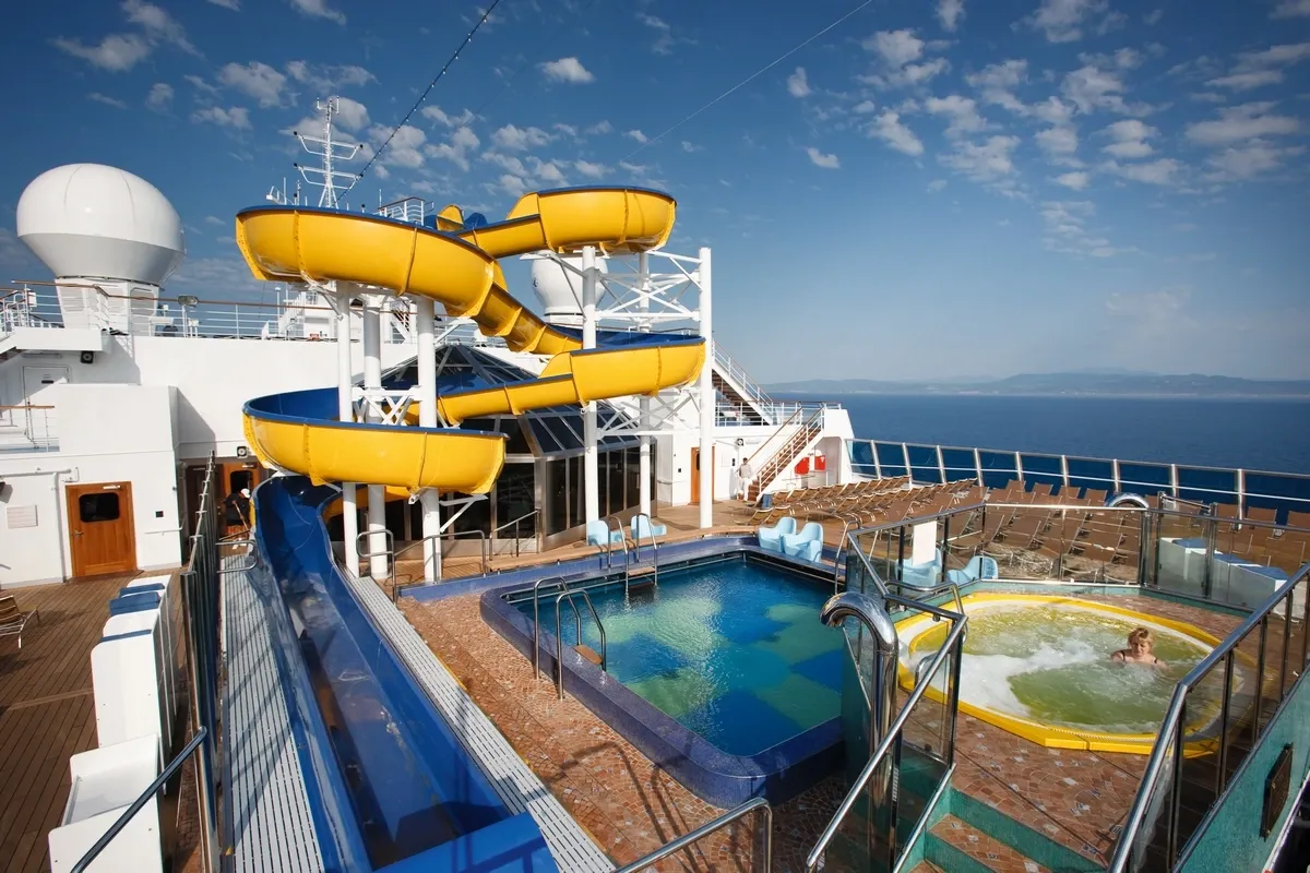 Pool and waterslides on a top deck of a cruise ship