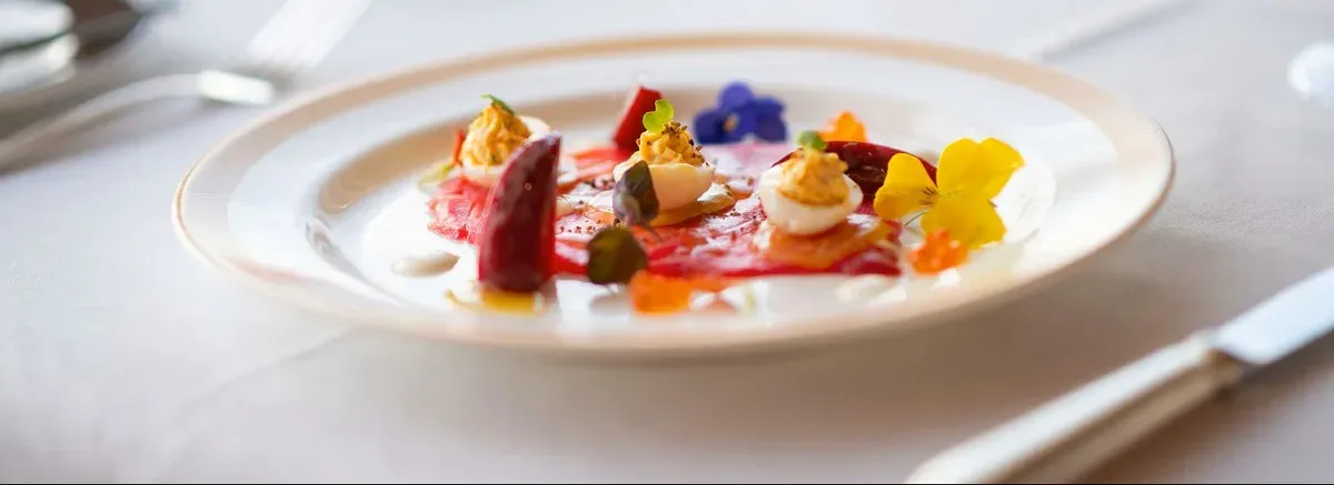 Detail view of a gourmet dish with eggs and flowers