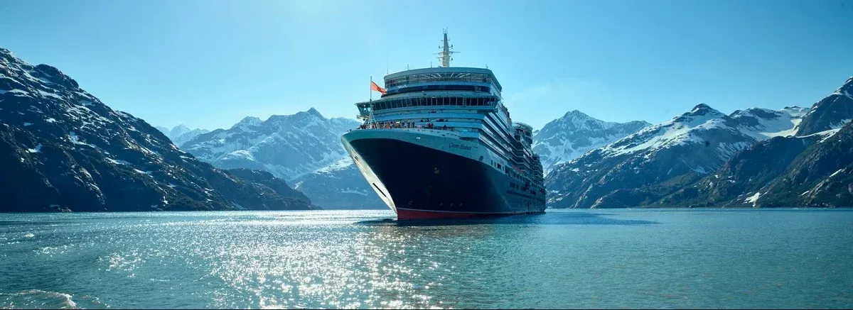 Cunard Cruise Line ship sailing with mountains on the background