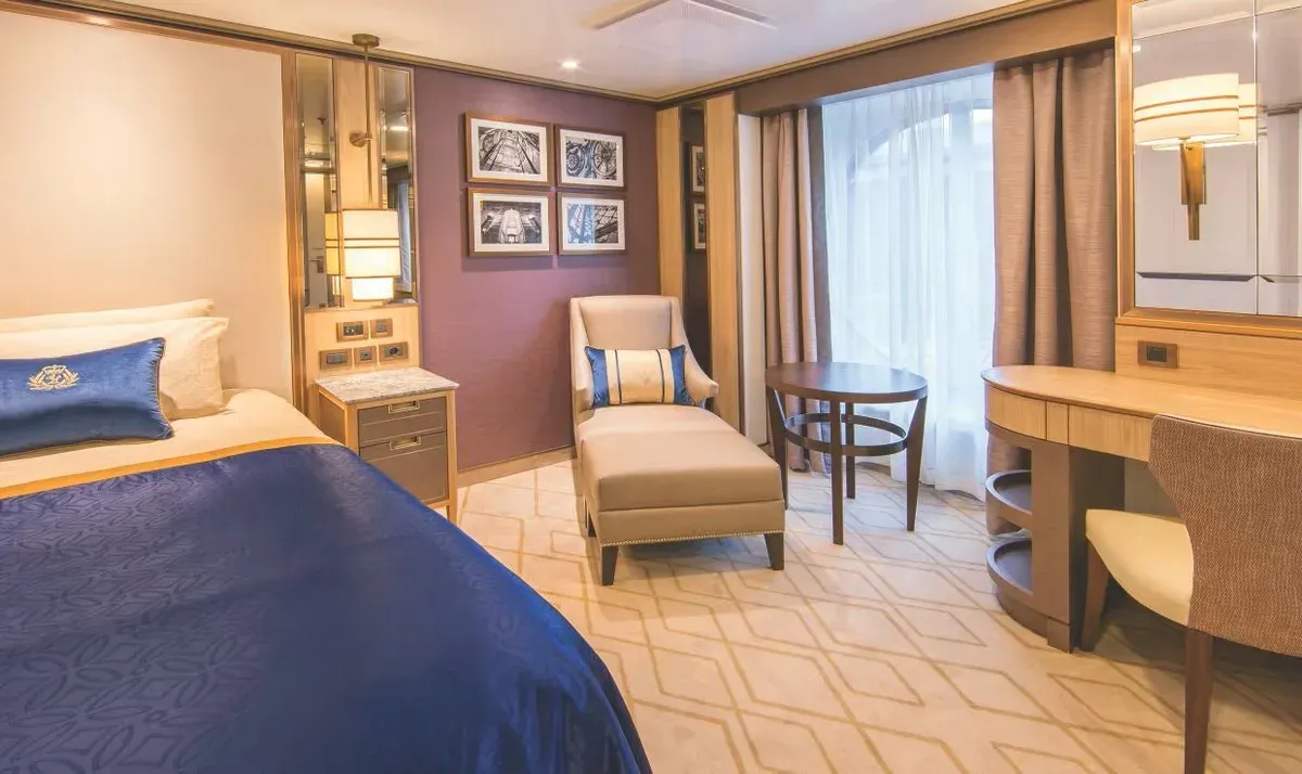 Cruise ship stateroom with a bed and living space