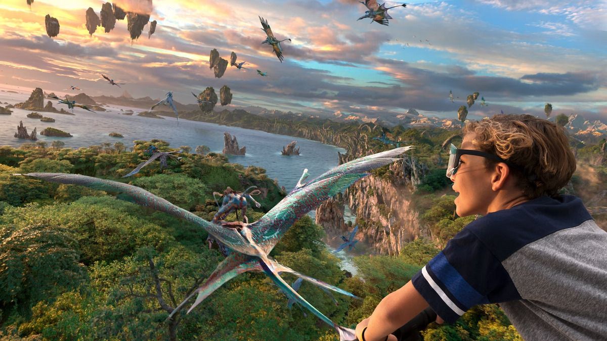 A young person wearing 3D glasses leans forward, immersed in a virtual reality experience of a lush, fantastical landscape with floating islands and creatures flying in the sky. The scene is expansive, with a colorful creature soaring close by, enhancing the sense of adventure.