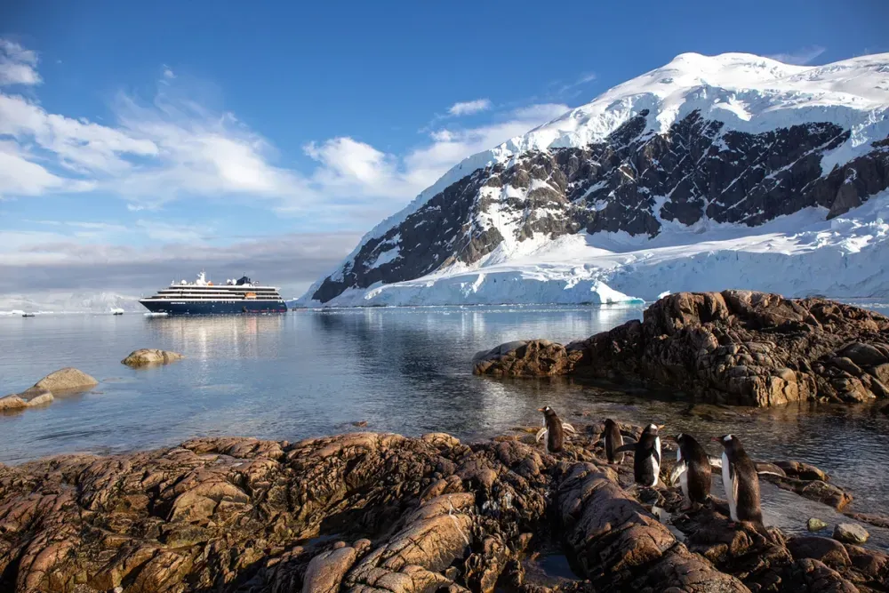 Cruise ship sailing next to a snowed mountain