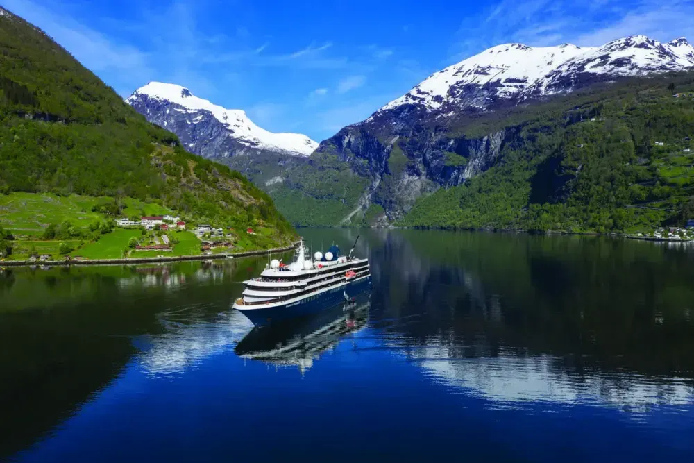 Cruise ship sailing on a river between two mountains