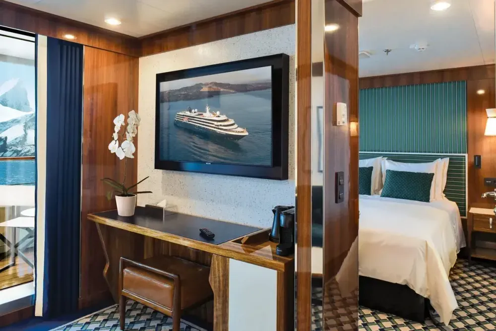 Suite view with a desktop and a queen bed in the background