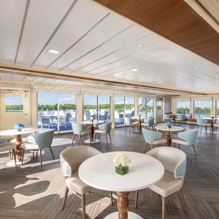 Cruise ship lounge room with many tables on a sunny day